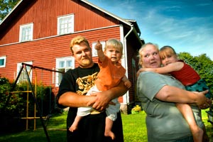 Tomi Vastamäki och Sanna Marjamäki tillsammans med sina barn Kasper och Julie njuter av sommaren på det gamla trädhusets gårdsplan. Foto: JUHA SINISALO