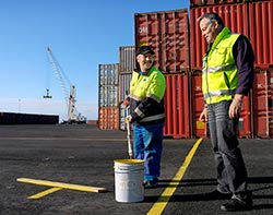 Underhllsarbetarna Esa Marjakaarto och Yrj Kauppila mlar trafikrnder p det splitternya omrdet i containerhamnen. Foto. RIINA NURMINEN
