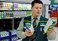 Heikki Luhtanen visar upp butikens ekomjkprodukter. Foto: HARRI NURMINEN