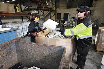 Janne Warell och Heidi Suominen sorterar bl a sladdar och kablar som kastas i stora containrar fr vidare transport till olika fretag fr tervinning. Foto. JOHANNES TERVO