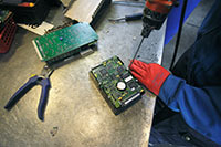 Elektronikskrotning måste i det första skedet, när man sorterar och tar isär delar, ske manuellt med enkla handverktyg. Det är ett bitvis tungt jobb som kan ge belastningsskador. Foto: JOHANNES TERVO