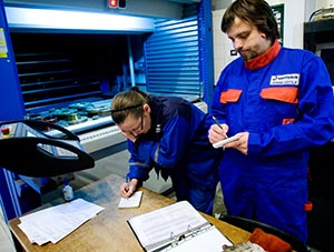 Lagerarbetaren Maija Pietil och Jonne Uotila samtalar med hjlp av papperslappar. Foto: ROBERT SEGER