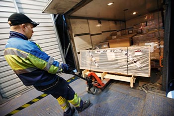 Chauffrerna p distributionsbilar p stads- och nromrdesrutter arbetar omkring tvtredjedelar av tiden utanfr chauffrshytten. Hr lastar Jukka Puolakanaho tunga kksbnkar i Kaukokiitos terminal. Foto: ALEKSI MAKKONEN